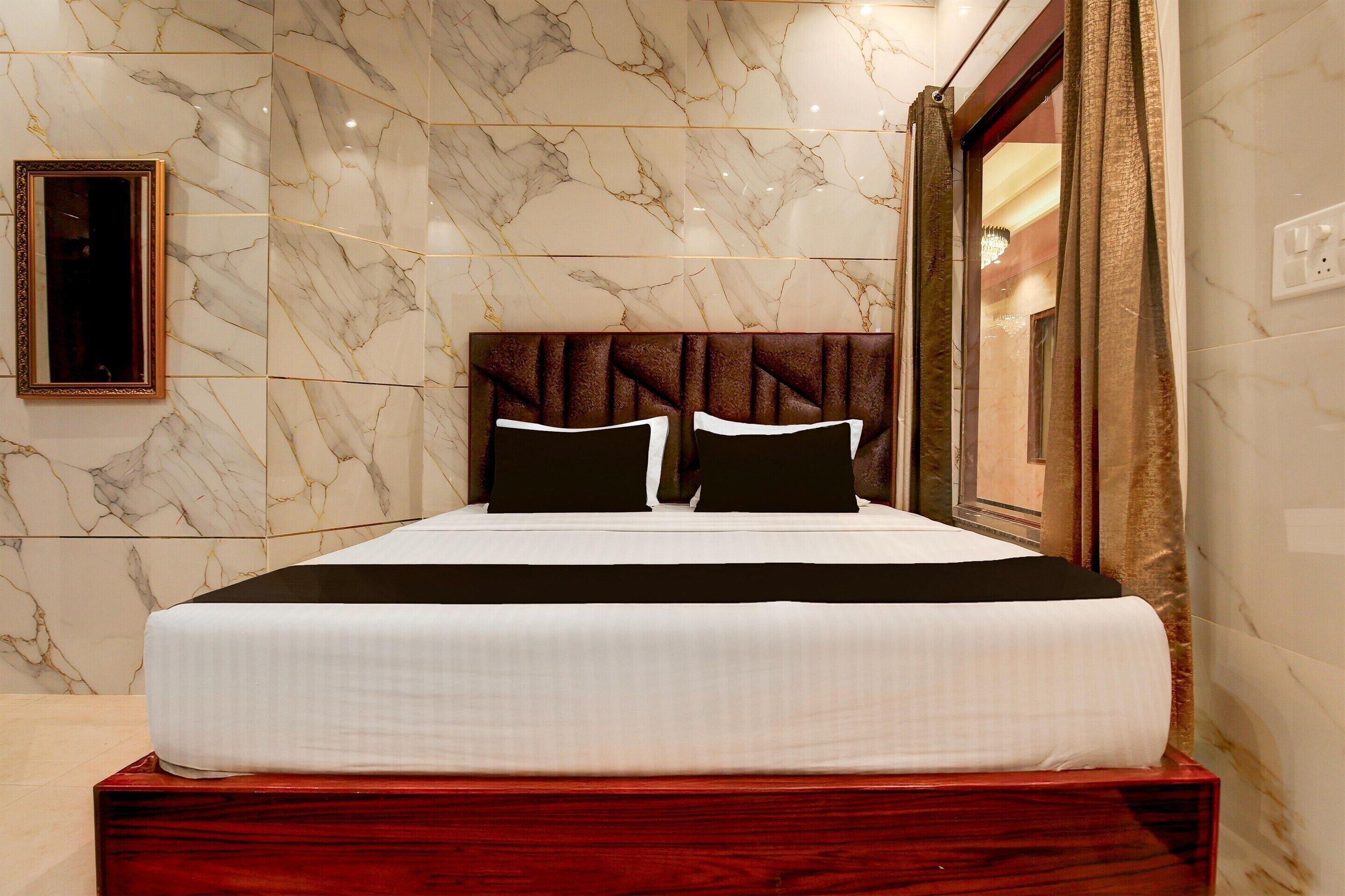 A bed with a headboard, a mirror, and a curtain.