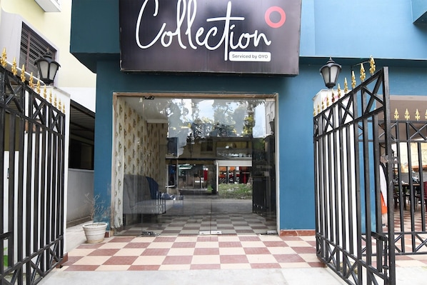 La entrada de un edificio con un letrero que dice 'Collection' y una verja negra con detalles dorados.