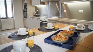 Een moderne keuken met een ontbijttafel, compleet met croissants en sinaasappelsap.
