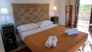 A bed with a headboard, two bedside tables, a lamp, and a towel on the bed. - House Sogni di Giove With Private Pool (Syracuse)