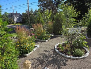 Un jardín con diversas plantas y una estatua.