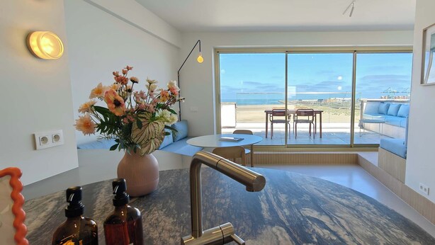 A modern bathroom with a large window, a sink, and a vase of flowers. - Beachfront Loft Terrace & Sea View in Zeebrugge (Brugge)
