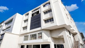 Un edificio moderno con un llamativo cartel que dice 'Collection', grandes ventanales y una escalera a la derecha.