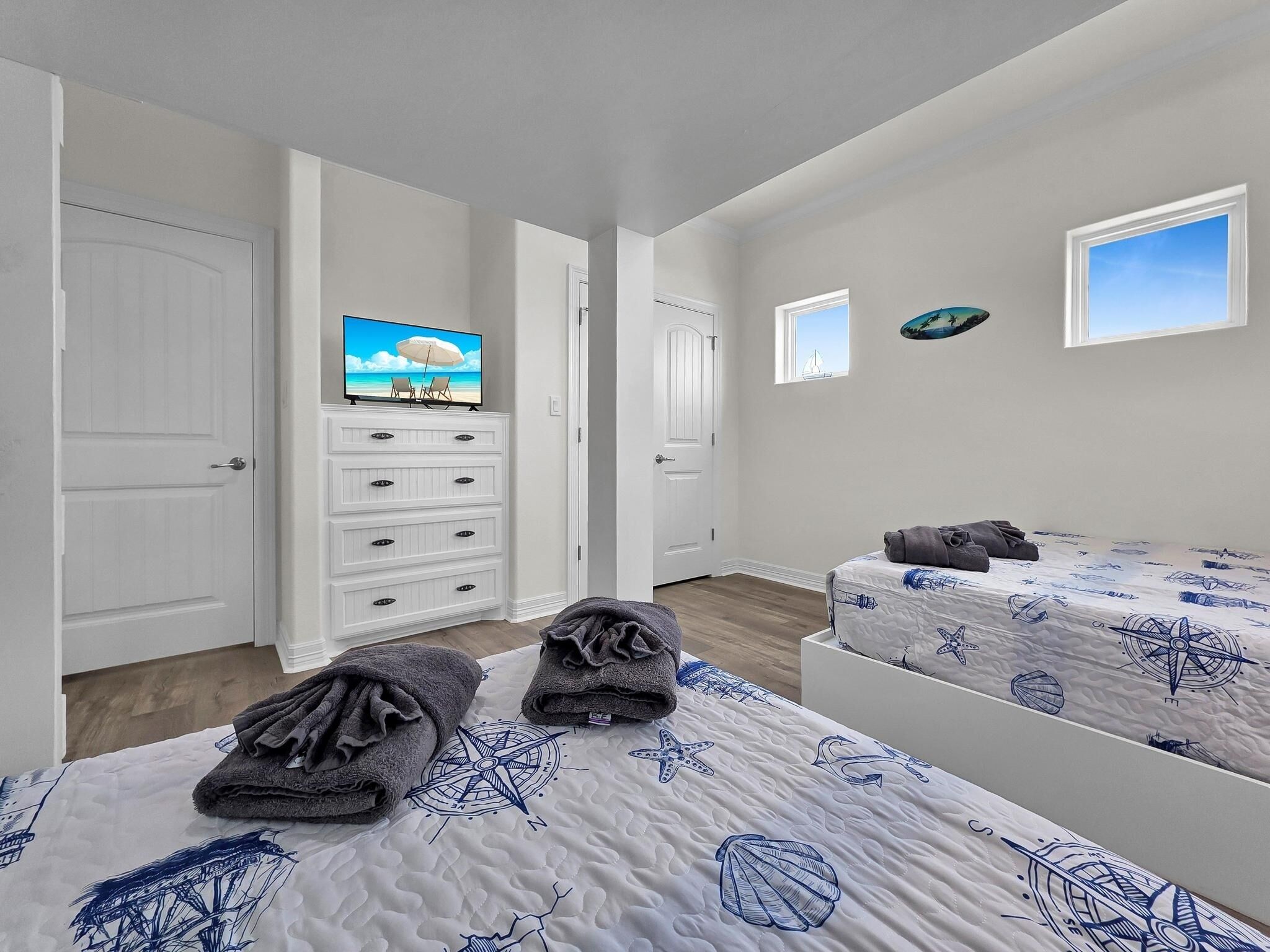 Un dormitorio con dos camas, un televisor y un aparador.