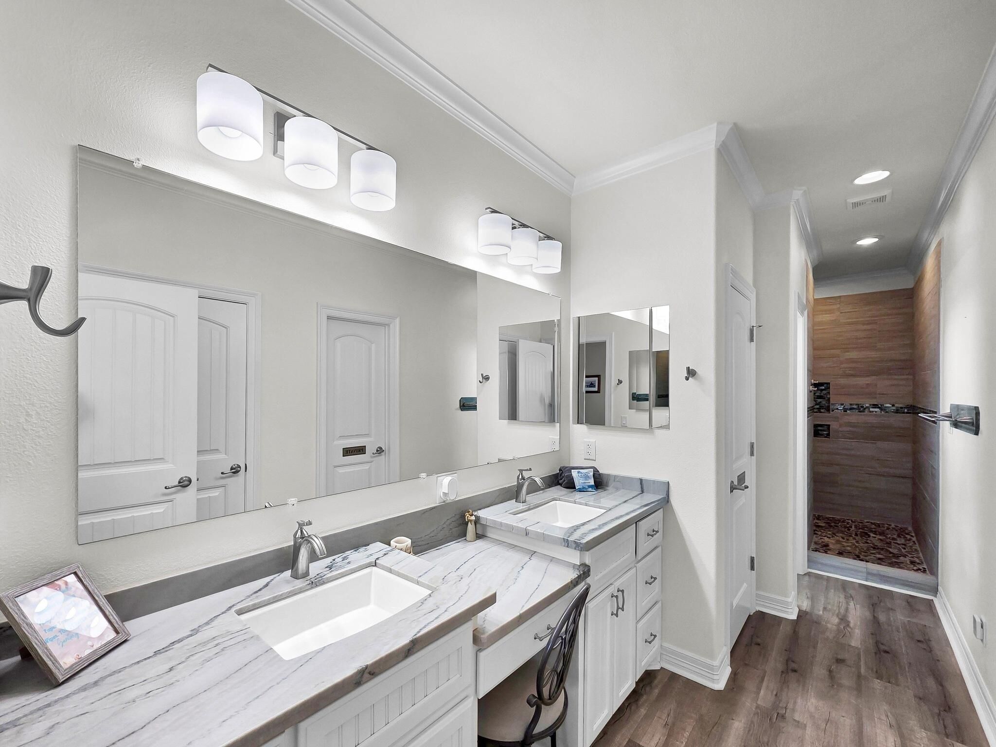 Un baño moderno con dos lavamanos, un espejo grande y una zona de ducha.