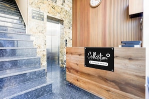 A reception desk with a sign reading 'Collection' and a clock on the wall.