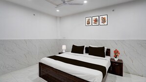 Quarto com cama, mesas de cabeceira, ventoinha no teto e obras de arte nas paredes.