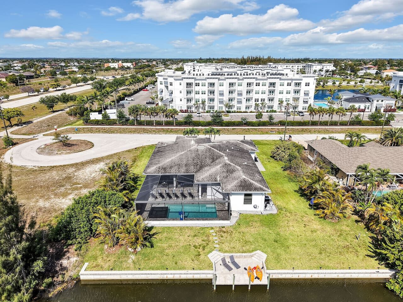 Un hôtel avec une piscine, un grand bâtiment en arrière-plan et un élément décoratif aquatique au premier plan.