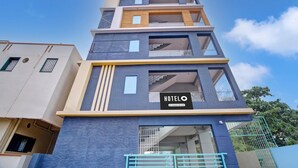 Un hotel de varios pisos con un llamativo letrero que dice 'HOTEL', balcones y una escalera.