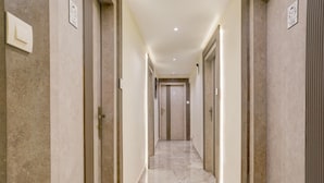 A corridor with marble flooring, doors on both sides, and recessed lighting. - Super Collection O Ghodbunder Road (Mumbai)