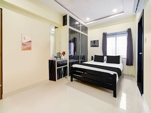 Un dormitorio moderno con una cama, una tocador con espejo, un escritorio pequeño y una ventana con cortinas.