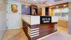 A hotel reception desk with a 'HOTEL' sign, a ceiling fan, and a decorative wall piece. - Suite Super Hotel O Anna Nagar Madurai (Madurai)