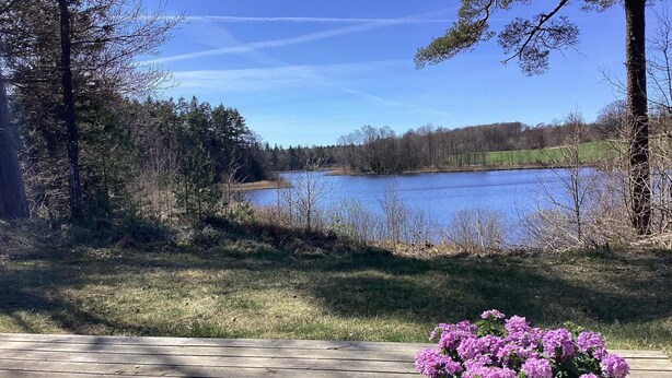 A wooden deck with a view of a lake and trees. - 4 Star Holiday Home in Skanes-fagerhult (Skånes Fagerhult)