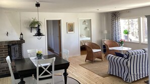 A modern living room with a dining area, a fireplace, and a view of a bedroom. - 4 Star Holiday Home in Skanes-fagerhult (Skånes Fagerhult)