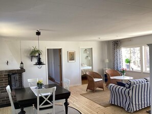 A modern living room with a dining area, a fireplace, and a view of a bedroom. - 4 Star Holiday Home in Skanes-fagerhult (Skånes Fagerhult)