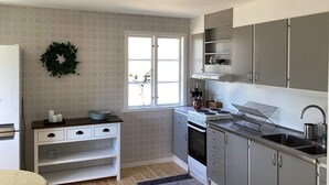 A compact kitchen with a window, built-in cabinets, a stove, and a sink. - 4 Star Holiday Home in Skanes-fagerhult (Skånes Fagerhult)