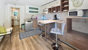 Uma cozinha compacta com ilha central, micro-ondas e cafeteira.