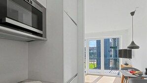 Una cocina moderna con microondas, estufa y comedor con mesa y sillas.