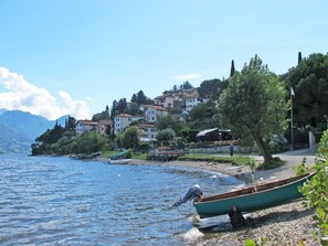 A lakeside view with boats, a tree, and buildings in the background. - Casa bel Lago by Interhome (Pianello Lario)