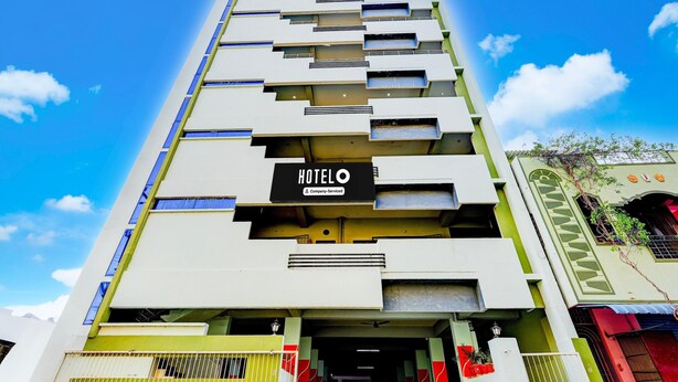 A multi-story hotel with a sign indicating it is company-serviced. - Super Hotel O Tirupati Chennai (Tirupati)