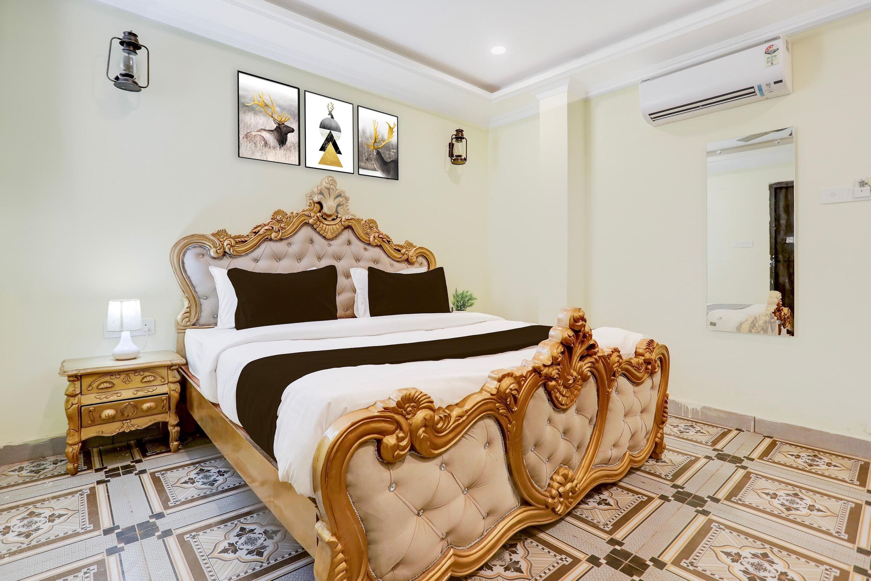 Un dormitorio con una cama grande, un cabecero ornamentado y una mesita de noche con una lámpara.