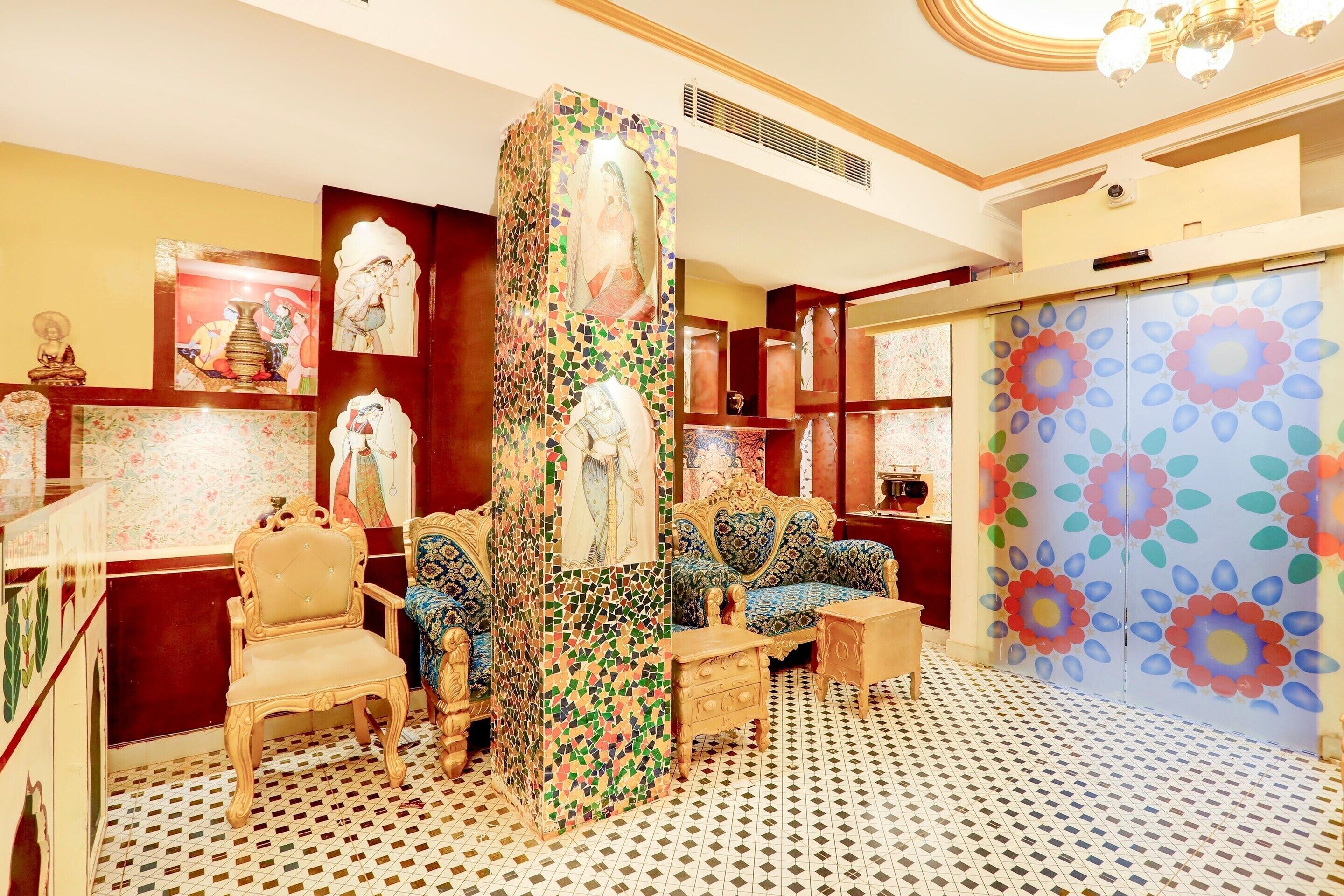 A room with a patterned floor, a central column with a mosaic, and a sofa with a floral design.