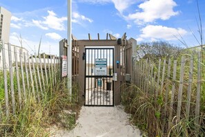 A gated entrance to a beach area with a sign indicating private property and beach access. - 2BR Pet Friendly Beach View Pool Sleeps 7 Condo! (Panama City Beach)