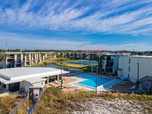Un complexe hôtelier doté d’une piscine, de plusieurs bâtiments et offrant une vue sur un ciel dégagé.