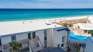 Ein Hotel mit Pool auf dem Dach, Blick auf den Strand und einer Palme.