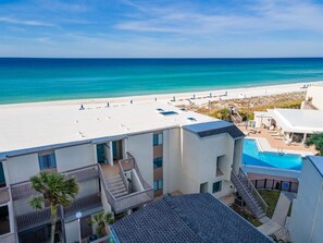 Un hotel con piscina, vista al mar y cielo despejado.