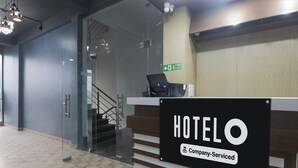 A hotel reception desk with a sign indicating it is company-serviced. - Deluxehotel Virat Inn (Gorakhpur)