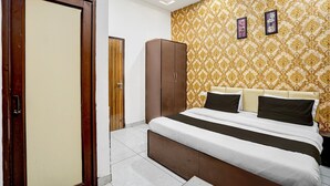 A bedroom with a bed, wardrobe, and a patterned wall. - Hotel O by OYO Silver Arc Mall Ludhiana (Ludhiana)