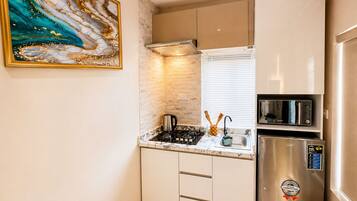 Deluxe Studio Suite | Private kitchen | Fridge, microwave, freezer