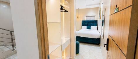 A hotel room with a bed, wardrobe, and a bathroom with a shower and toilet.