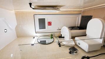 Une salle de bain moderne dotée d’une douche à parois de verre, de toilettes et d’un bidet.