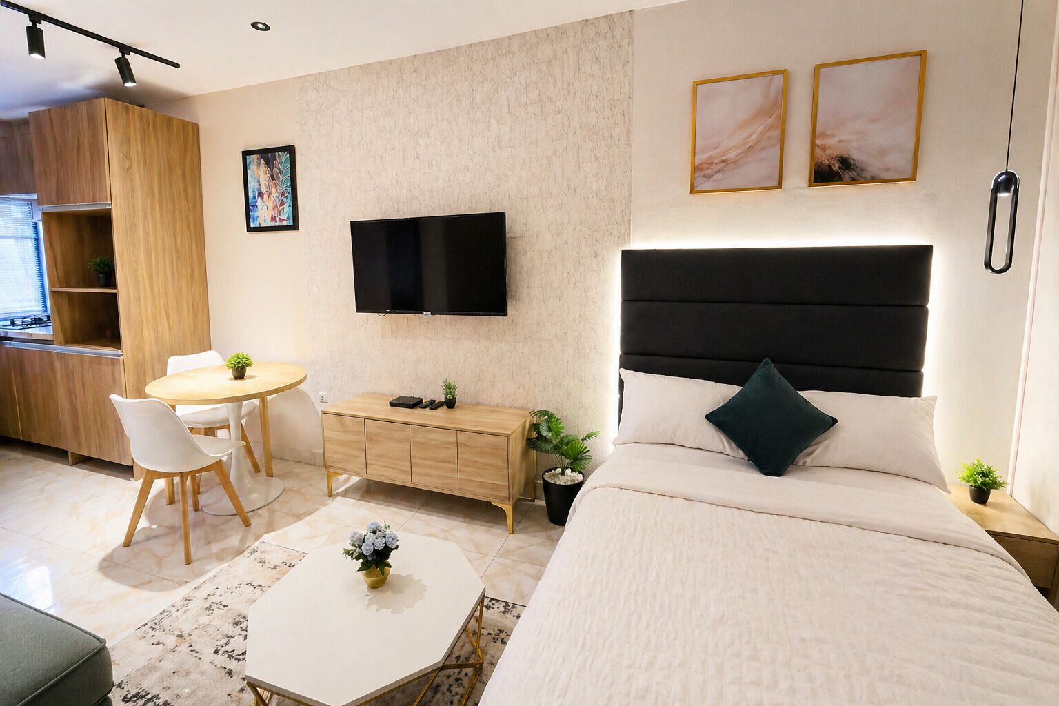 Ein modernes Hotelzimmer mit Bett, Nachttisch, Fernseher, Schreibtisch, Stuhl und einem kleinen Esstisch.
