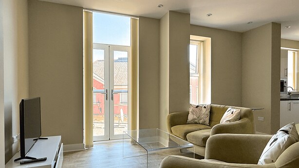 Ein modernes Wohnzimmer mit einer Couch, einem Glastisch und einem Fernsehschrank.