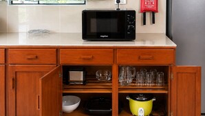Una cocina con microondas, tostadora y una cocción lenta amarilla.