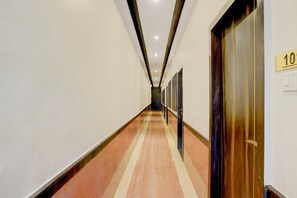 A hotel hallway with a number 10 door, a tiled floor, and a ceiling with recessed lighting.