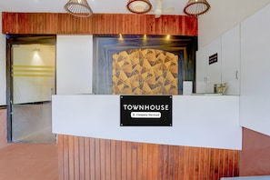 A reception desk with a 'Townhouse' sign, a wooden panel wall, and a geometric patterned wall behind it.