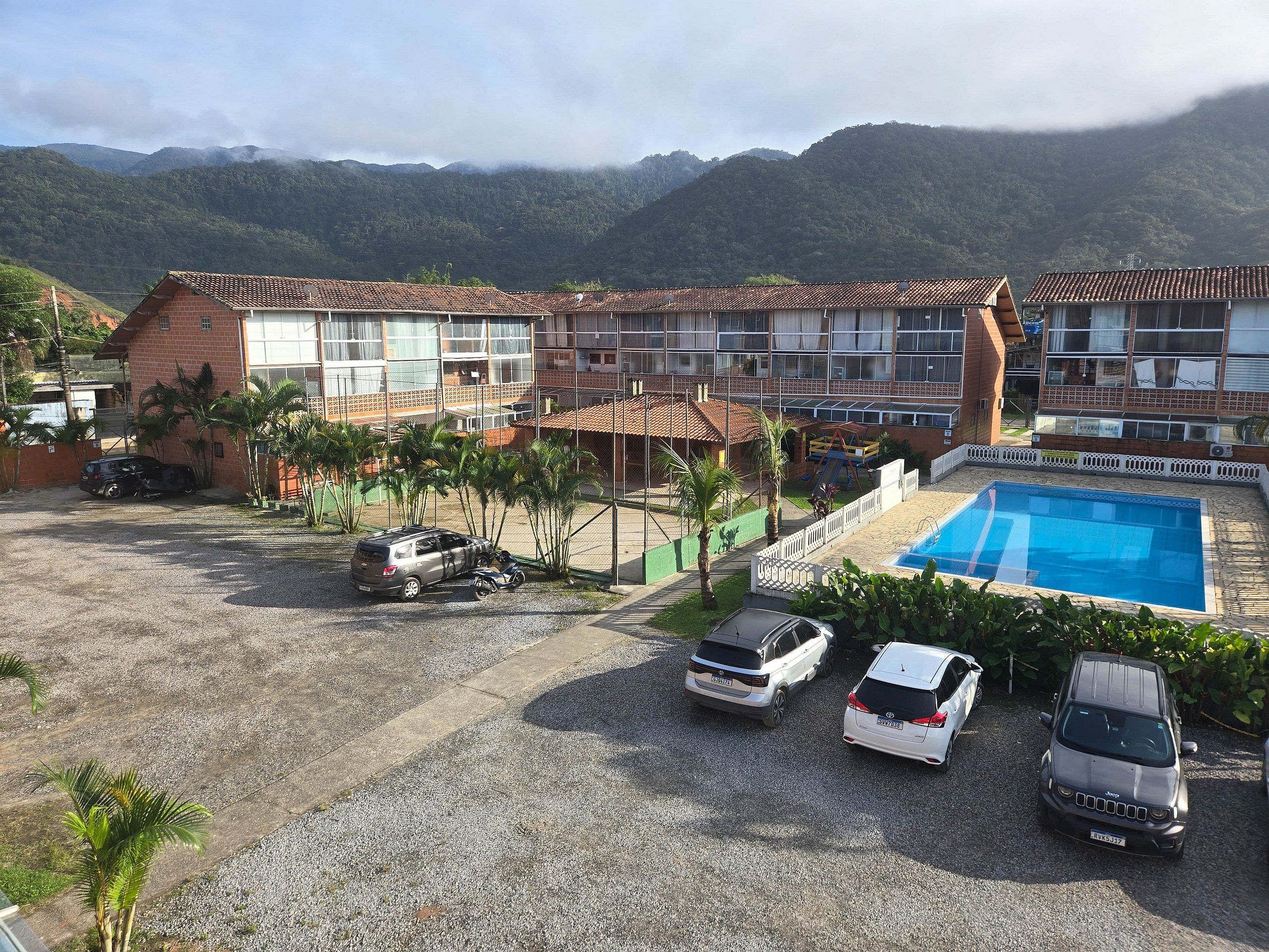 Un hôtel comprenant plusieurs bâtiments, une piscine et situé dans un cadre montagneux.