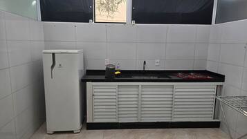 Uma cozinha compacta equipada com geladeira, pia e fogão.