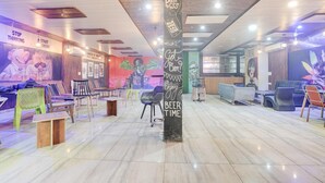 A modern interior with a central pillar, seating areas, and artwork on the walls. - Collection O Zirakpur Bus Terminal (Dera Bassi)