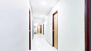 A corridor with doors, a potted plant, and a ceiling light. - Deluxe Townhouse VIP Hills Hitech City (Hyderabad)