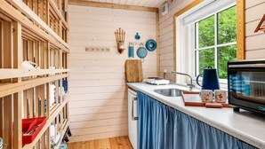 A kitchen with wooden beams, a window, and a microwave. - "Heda" - 1.6km to the fjord by Interhome (Hadsund)