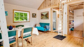 A cozy cabin interior with a dining area, a sofa, a ladder, and a bookshelf. - "Heda" - 1.6km to the fjord by Interhome (Hadsund)