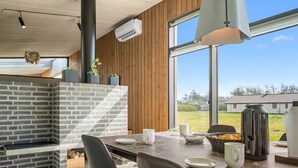 A modern kitchen with a brick wall, wooden paneling, and large windows. - "Safir" - 200m to the fjord by Interhome (Vinderup)