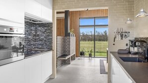 A modern kitchen with a brick backsplash, a large window, and a view of the outdoors. - "Safir" - 200m to the fjord by Interhome (Vinderup)
