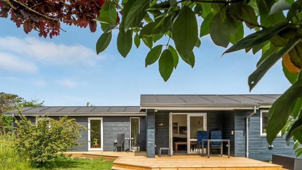 A modern house with a patio, a dining area, and a visible door. - "Tinka" - 100m from the sea by Interhome (Strandby)