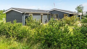 A modern two-story house with a dark exterior, large windows, and a visible satellite dish. - "Tinka" - 100m from the sea by Interhome (Strandby)